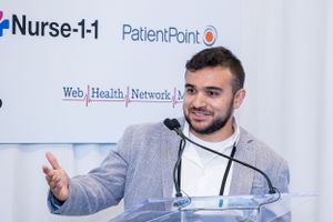 Professional speaker delivering remarks at podium with Nurse-1-1 and PatientPoint logos displayed.