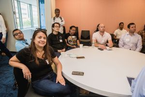 Attendees gathered around white round table during business meeting.