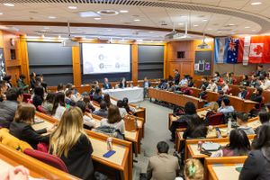 Lecture hall filled with attendees during a business presentation at Harvard.