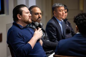 Panel discussion at a conference with speakers using microphones.