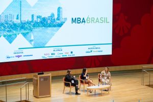 Wide shot of MBA Brasil conference stage with panel discussion in progress.