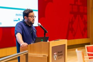 Speaker presents at podium during MBA Brasil conference event.