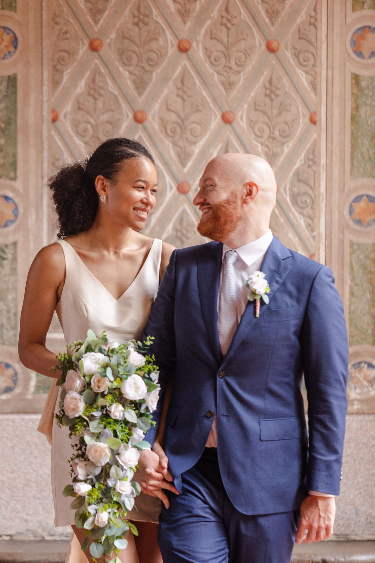 Elopement bride and groom looking at each other in Bethesda Terrace architecture background