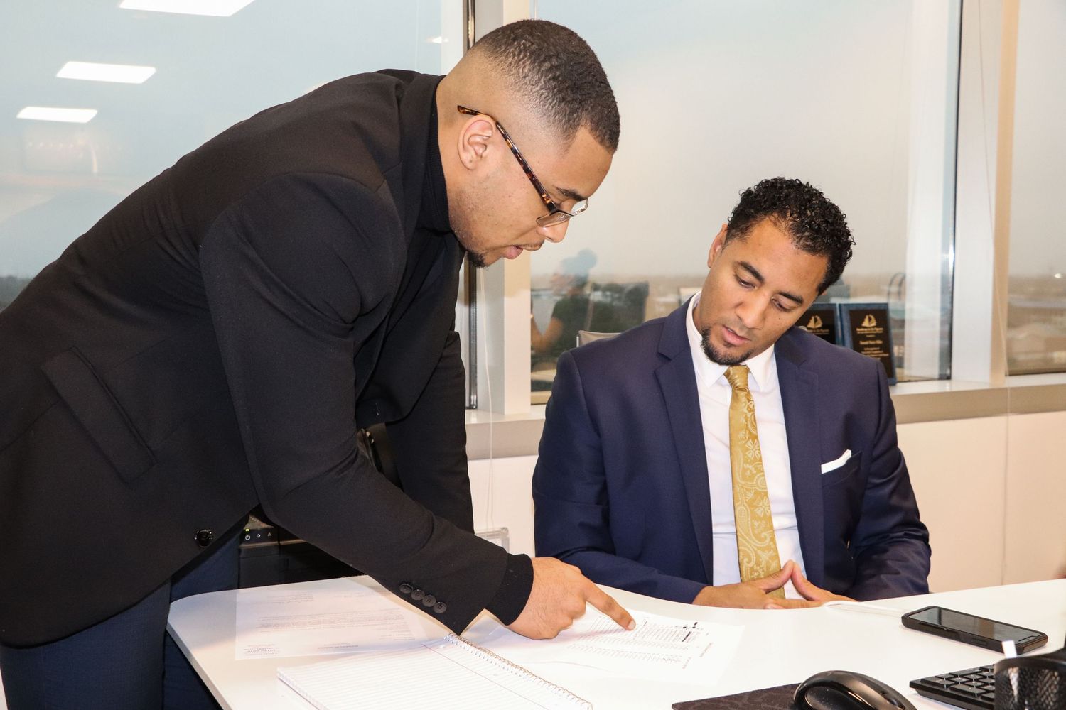 Business professionals reviewing documents together in modern office setting.