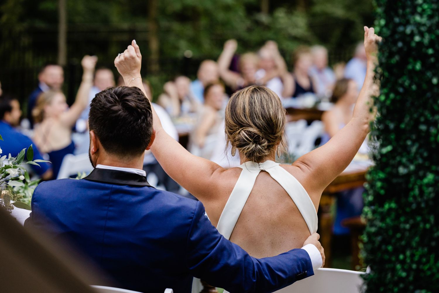 bride cheers on wedding guests at backyard wedding