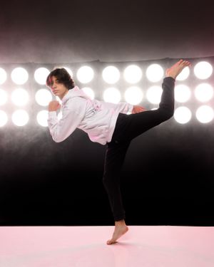 Dynamic dance movements shown against dramatic stage lighting and smoky atmosphere.