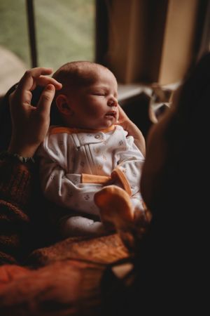 A peaceful sleeping baby being gently cradled in soft lighting.