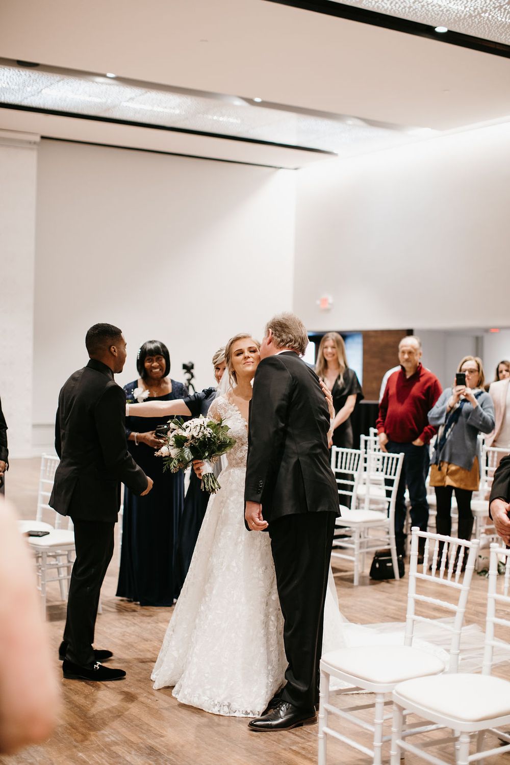 Father of the bride shares a kiss with his daughter at the altar during the wedding ceremony.