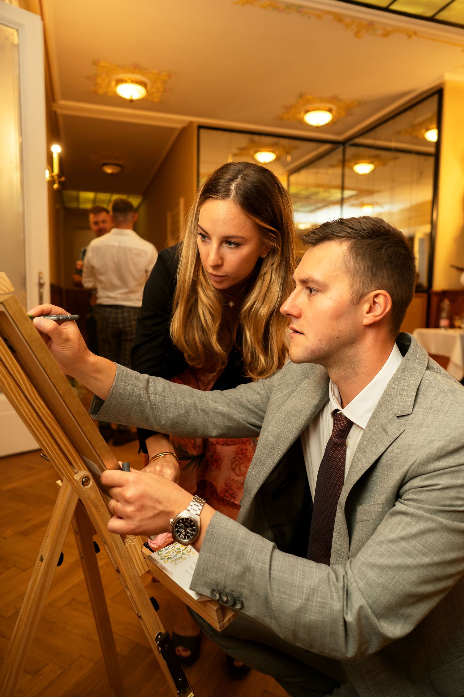 Signing the guestbook at an elegant wedding reception with mirrored walls.