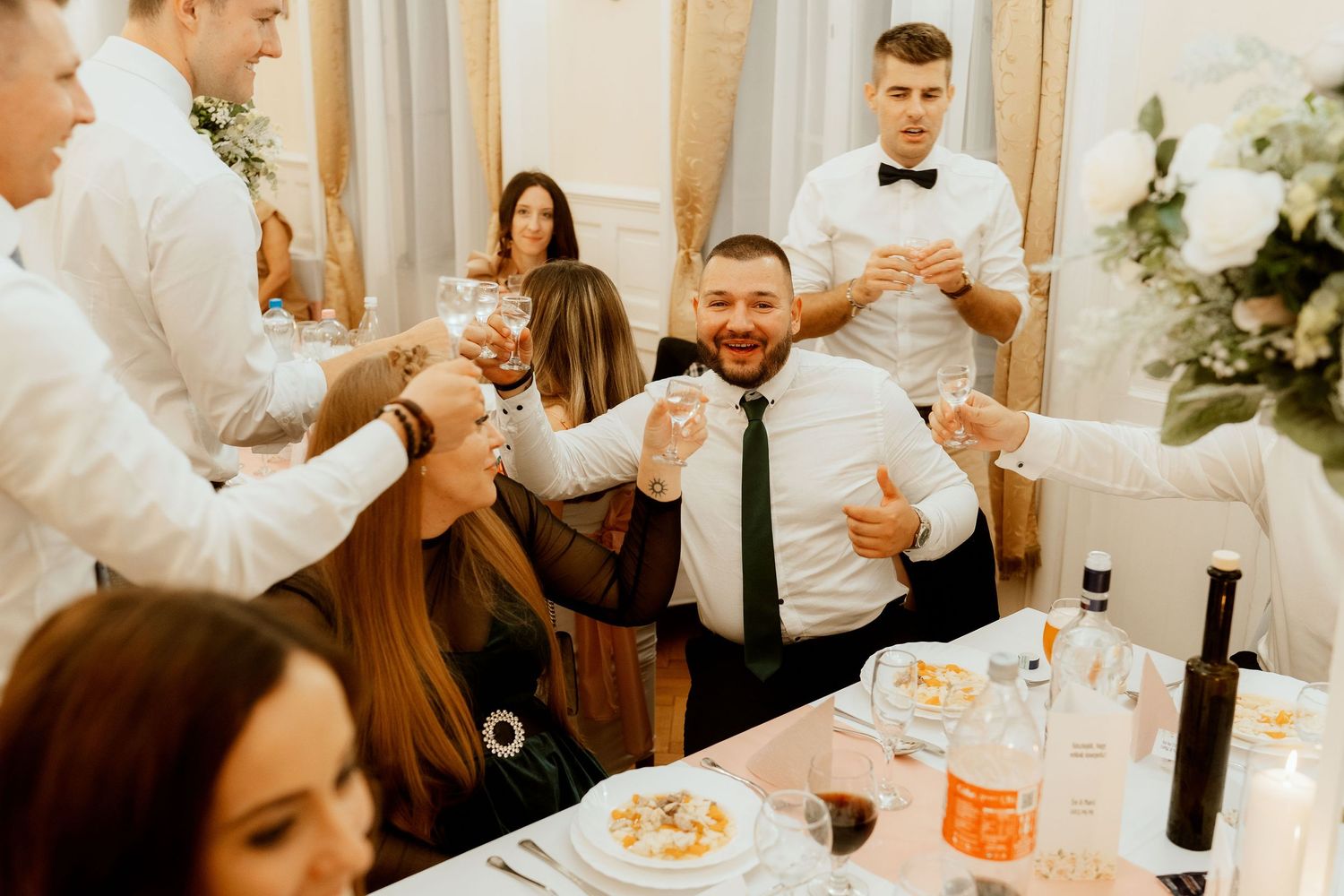 Lively wedding reception scene with guests enjoying dinner and conversation.