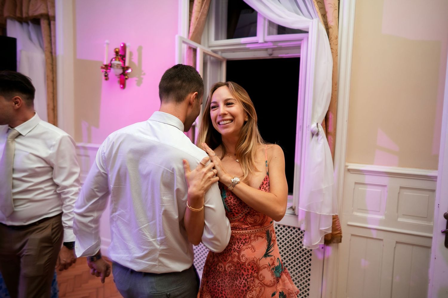 Guests enjoying a lively moment at a wedding reception in an elegant venue.