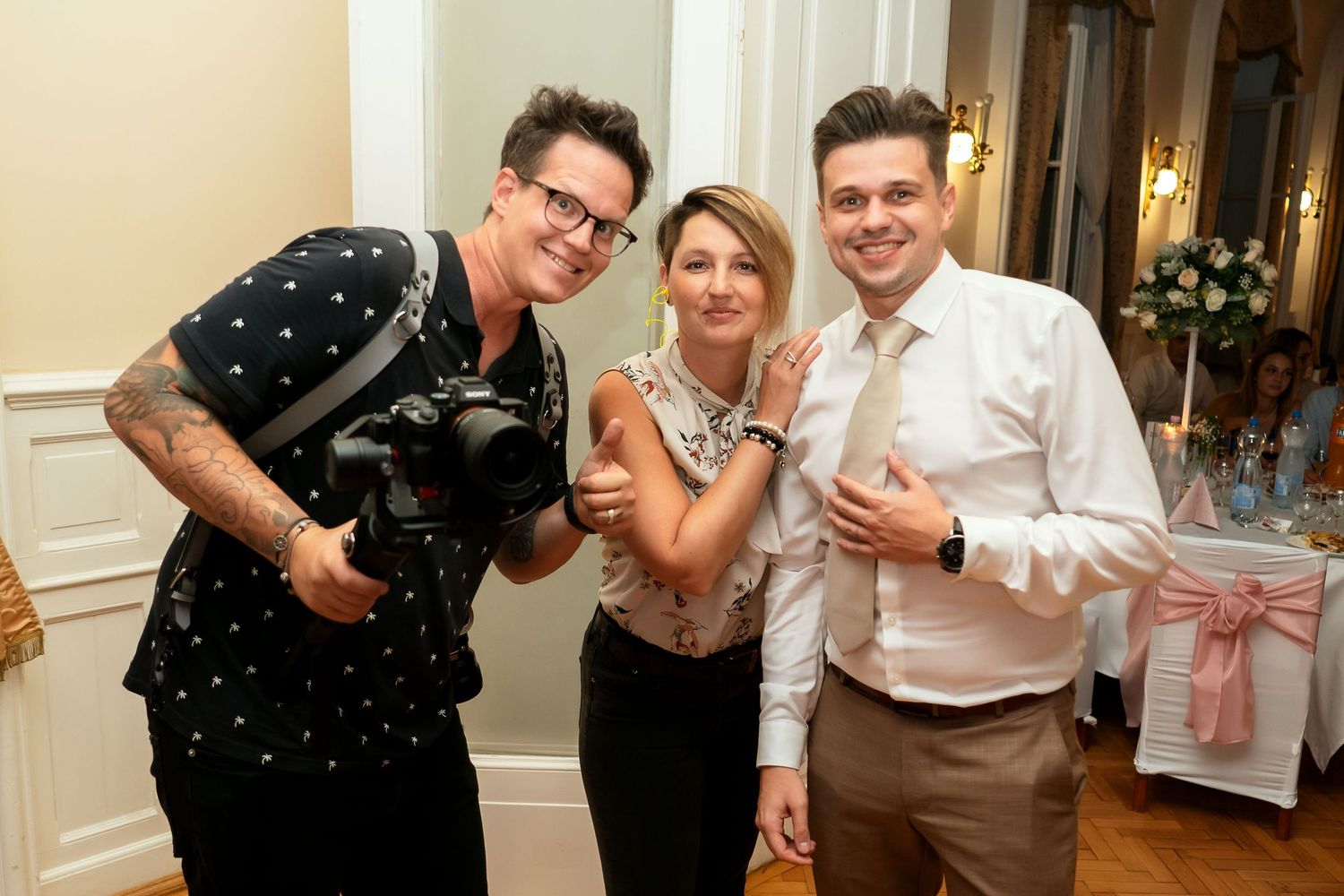 Wedding photographers and guest posing together at reception venue.