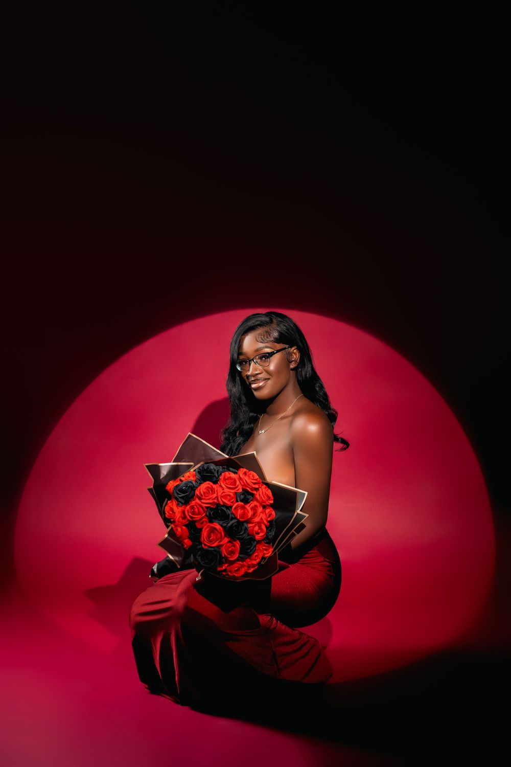 Glamorous studio portrait with red roses against dramatic red circular lighting.