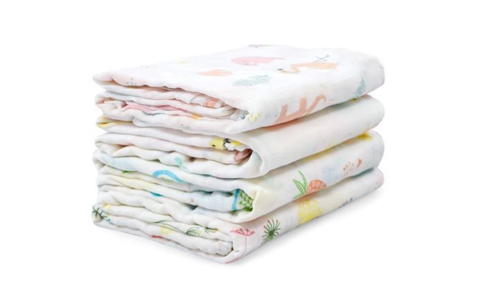 Stack of white folded baby diapers with colorful pattern designs.