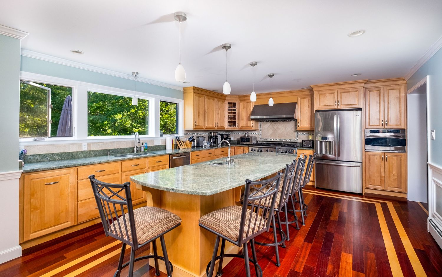 Grand kitchen with large island at a vacation rental property in Harrison, Maine.