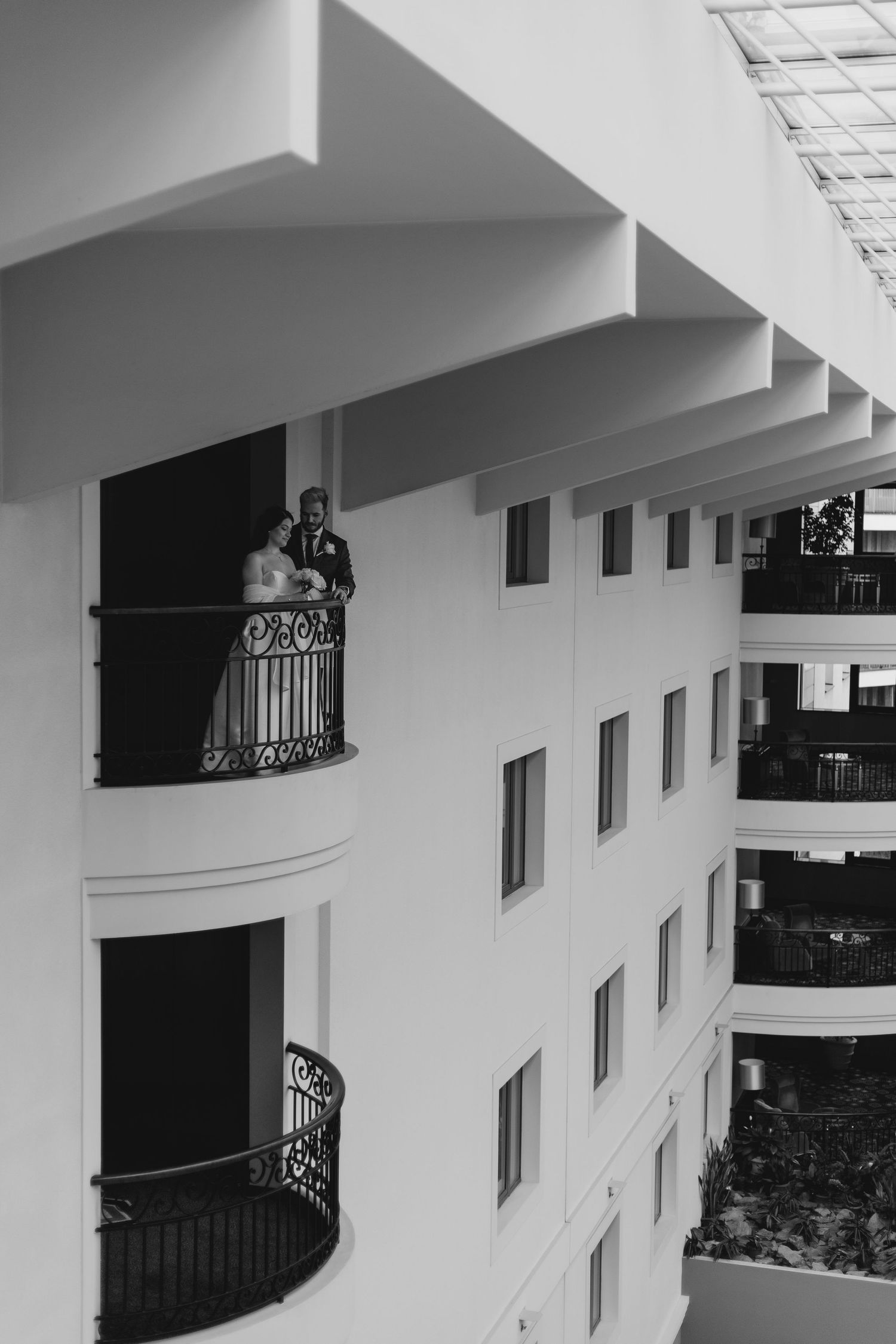 Elegant curved balconies with decorative railings on a white multistory building facade.