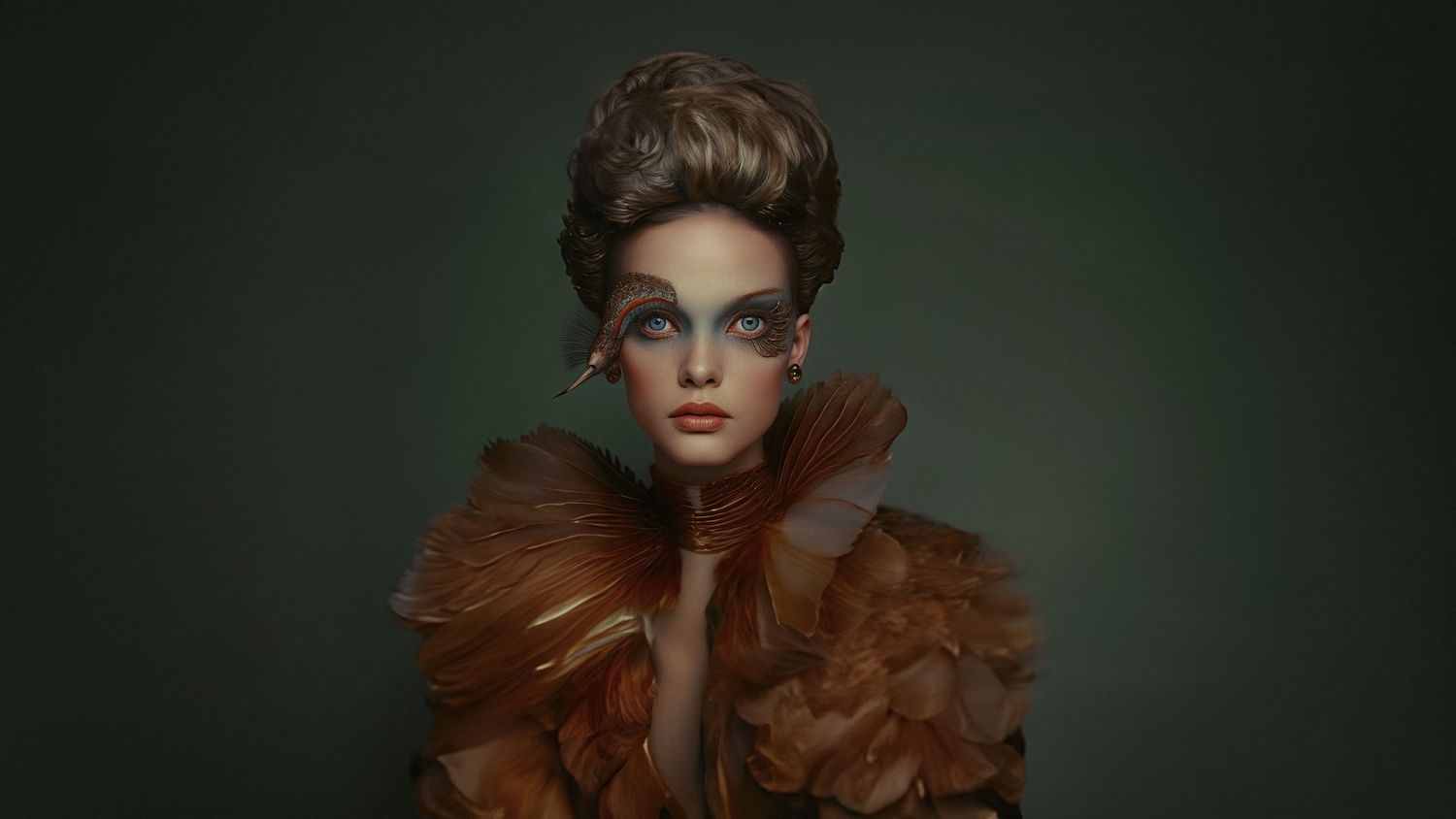 Dramatic fashion portrait against dark green background with elaborate copper-toned styling.