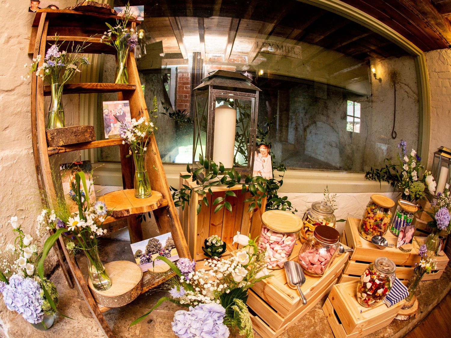 Rustic wedding venue decorated with colorful floral arrangements and wooden furniture.