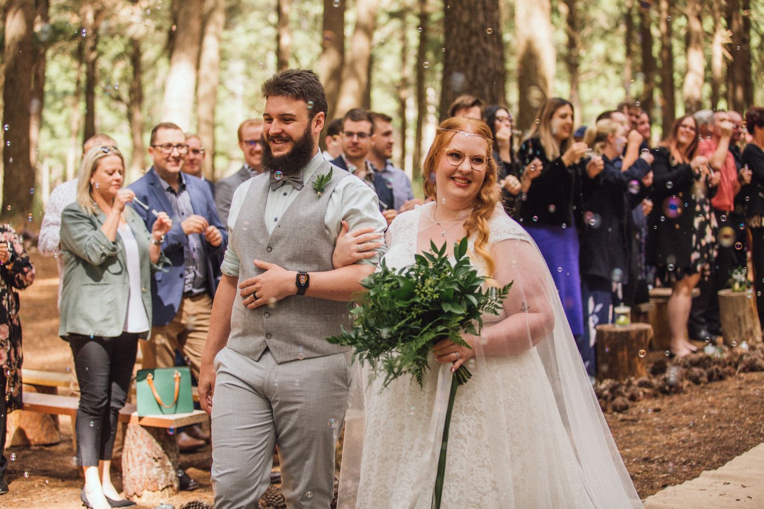 Alex and Ebony at Kuitpo Forest walking through an aisle of bubbles during their ceremony