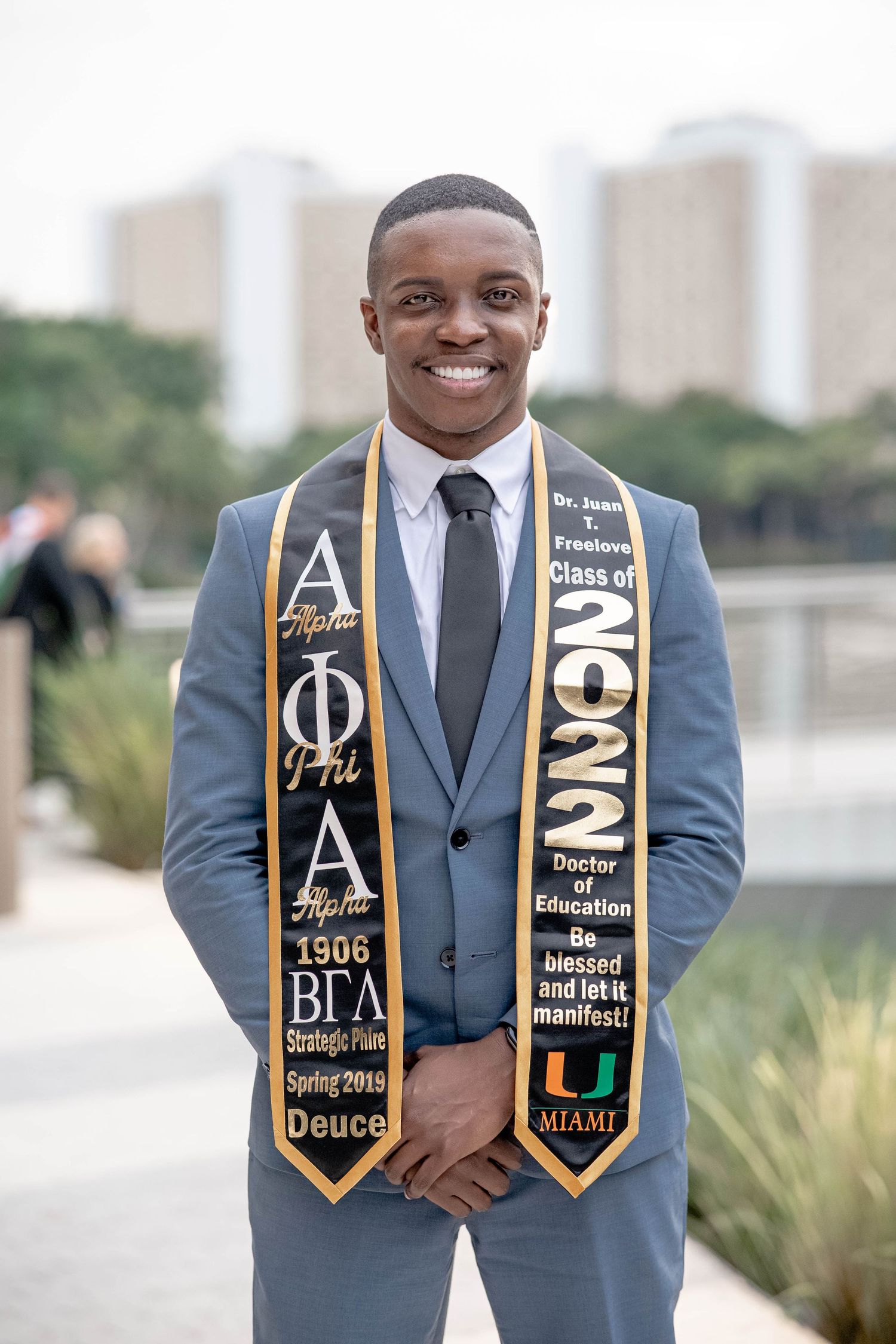 Smiling Black male graduate wearing University of Miami Class of 2022 Alpha Phi Alpha stole.