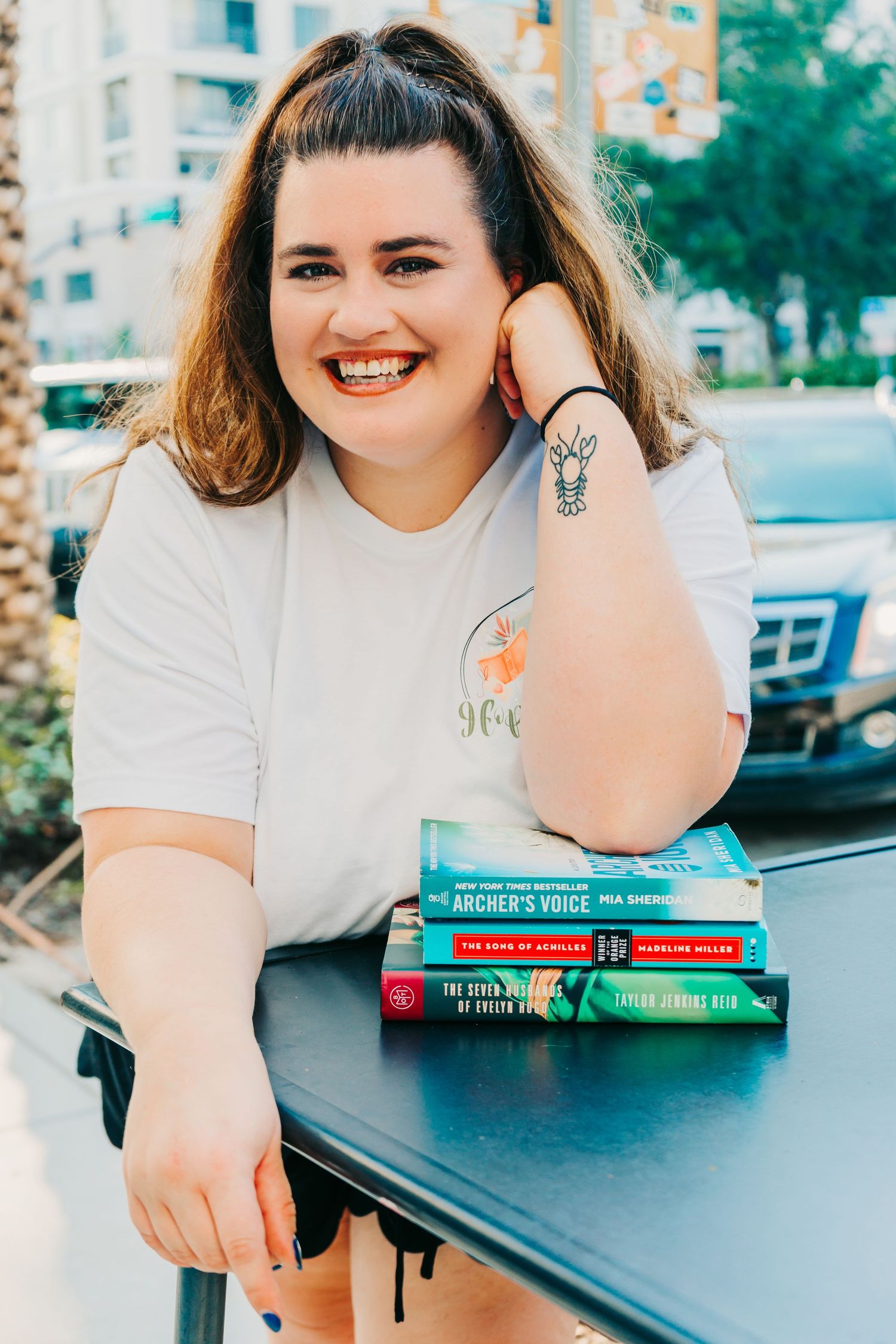 Outdoor Headshot Session in St. Pete, FL; Woman posing with stack of books