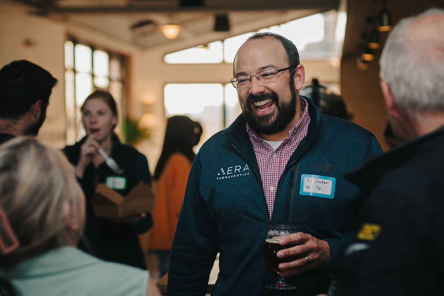 Person in business casual attire networking at an indoor corporate event.