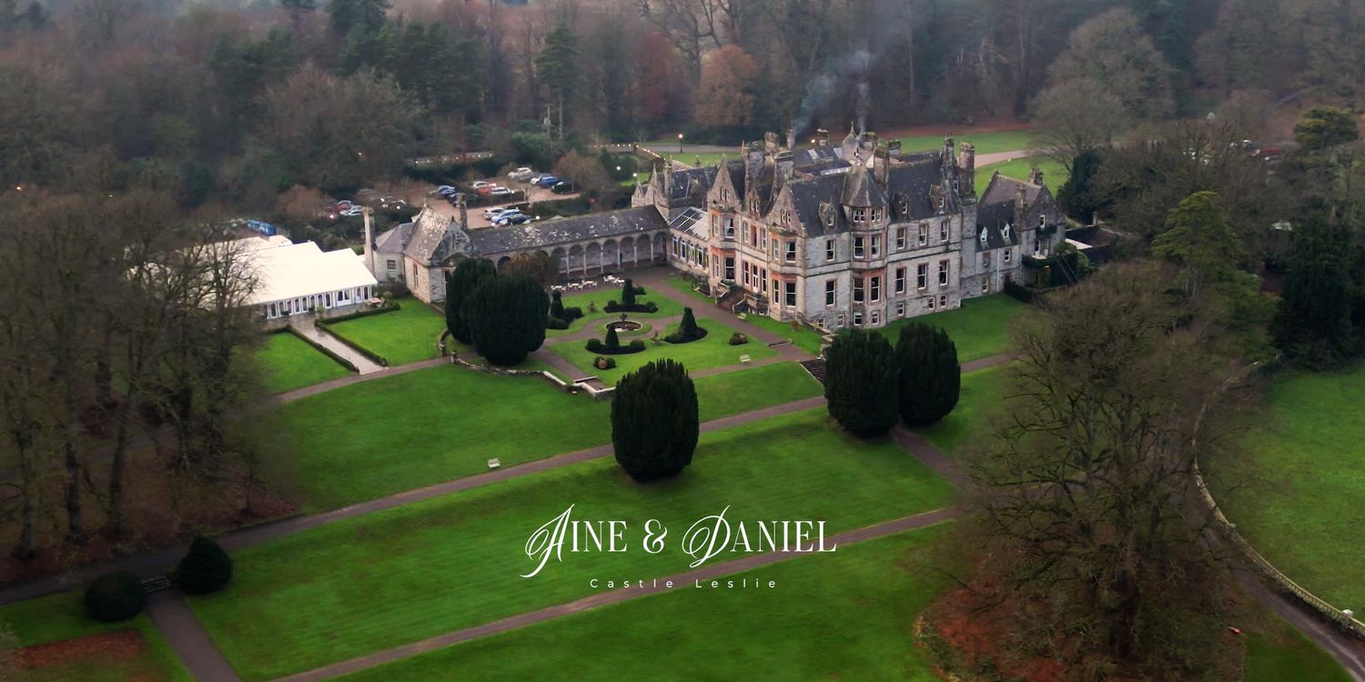 Aerial view of a grand estate surrounded by manicured lawns and woodland.