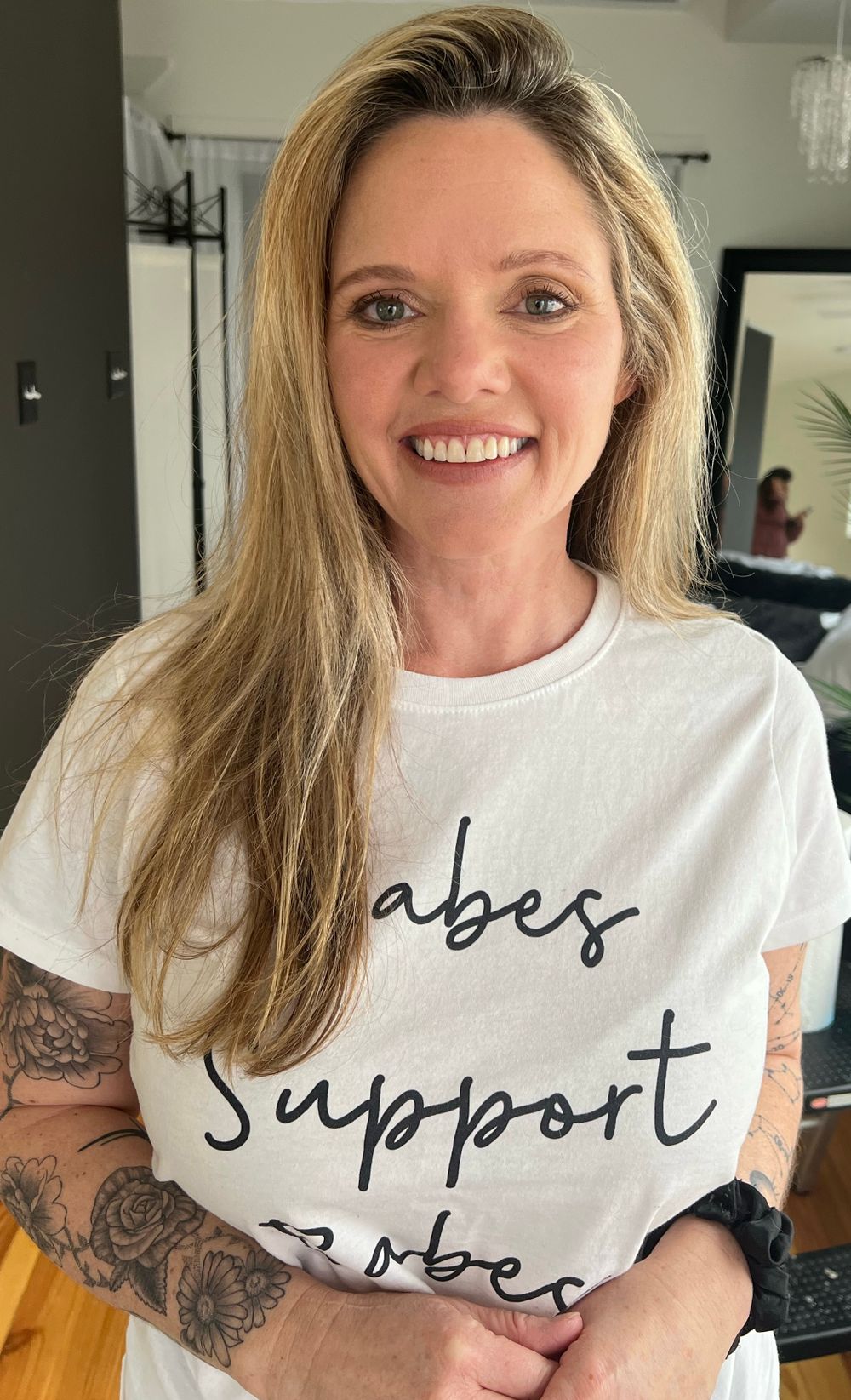 Person wearing white t-shirts with different text messages.