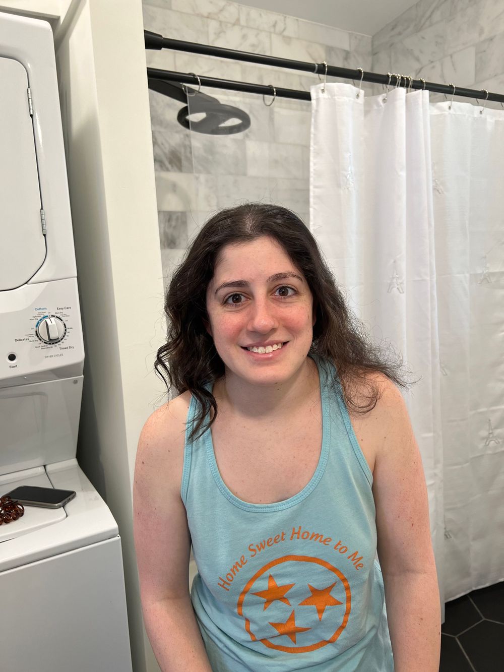 Person wearing light blue tank top with graphic design.