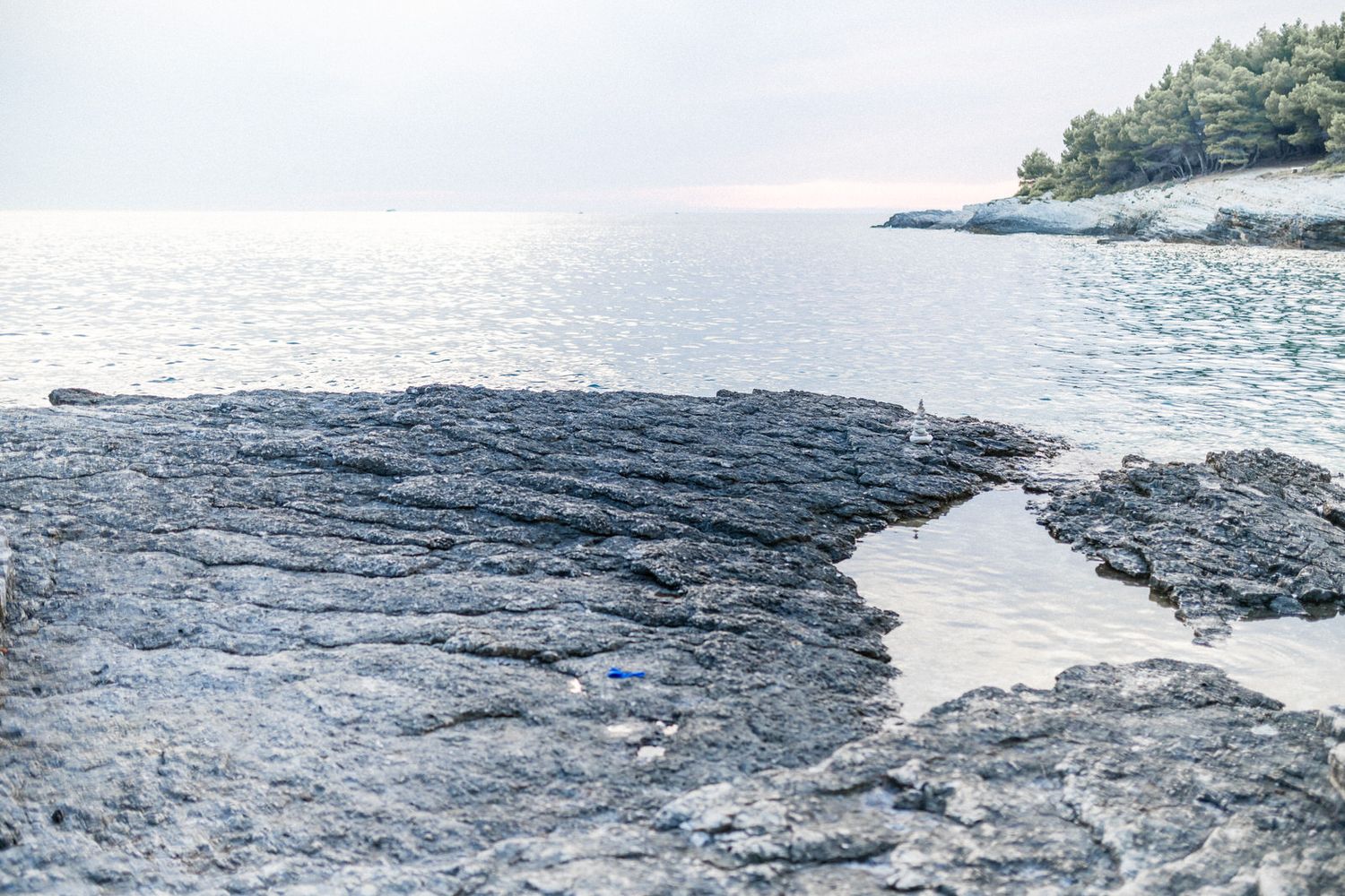 Dramatic rocky coastline formation meeting the calm sea waters.