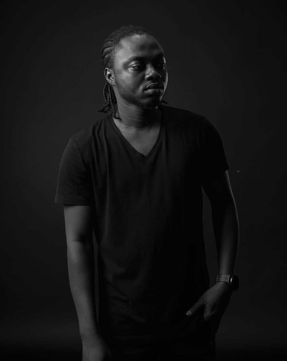 Artistic black and white portraits in low key lighting with person wearing black shirt.