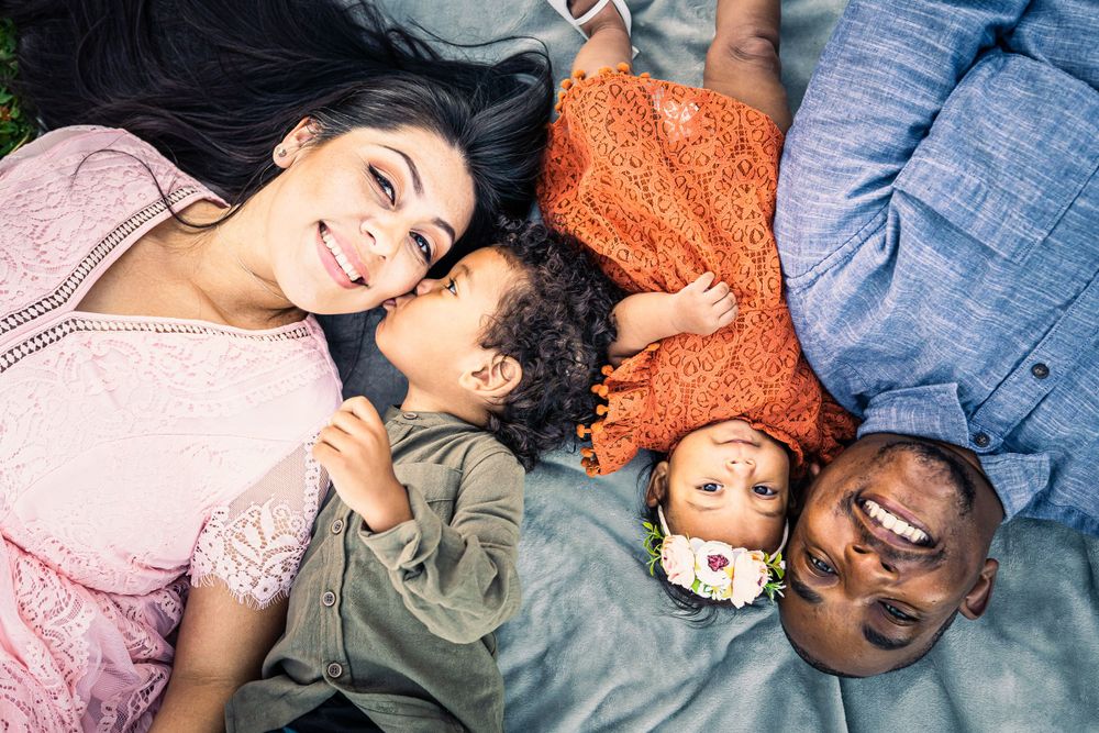 An overhead view of a family lying on the ground in a circle wearing casual attire.