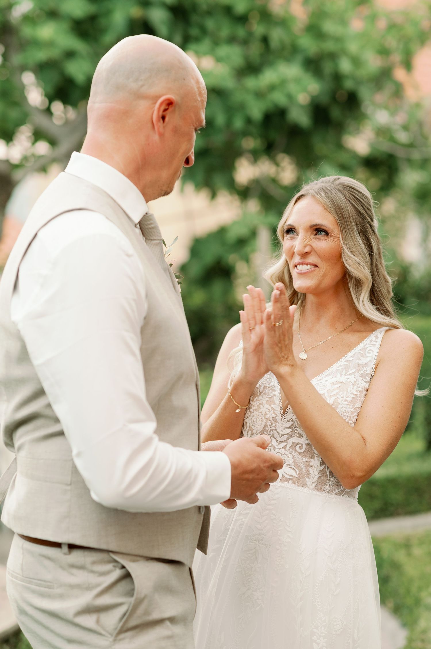 Emotional wedding moment captured during ring exchange in garden setting.