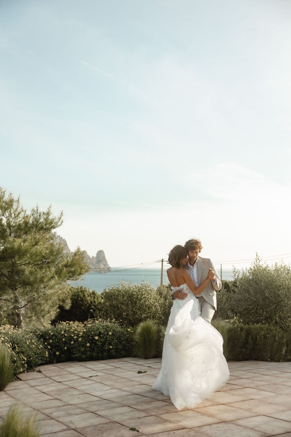 A romantic outdoor wedding photoshoot with coastal cliffs in the background.