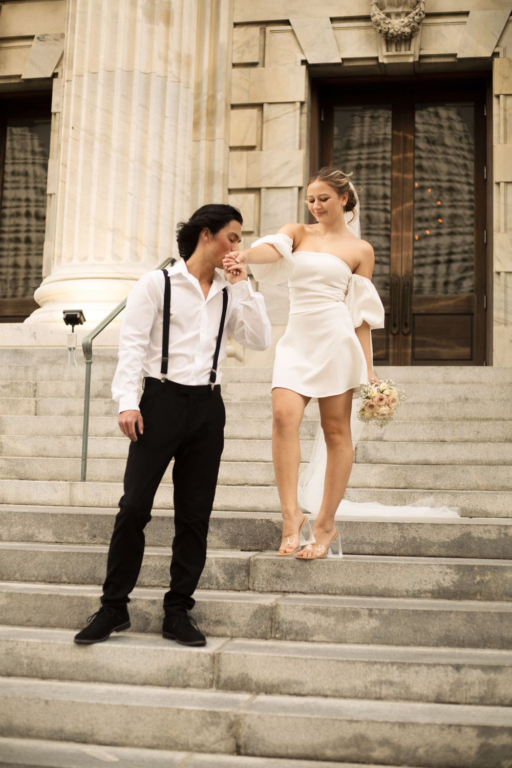 Romantic moment between couple on classic stone staircase during wedding photoshoot.