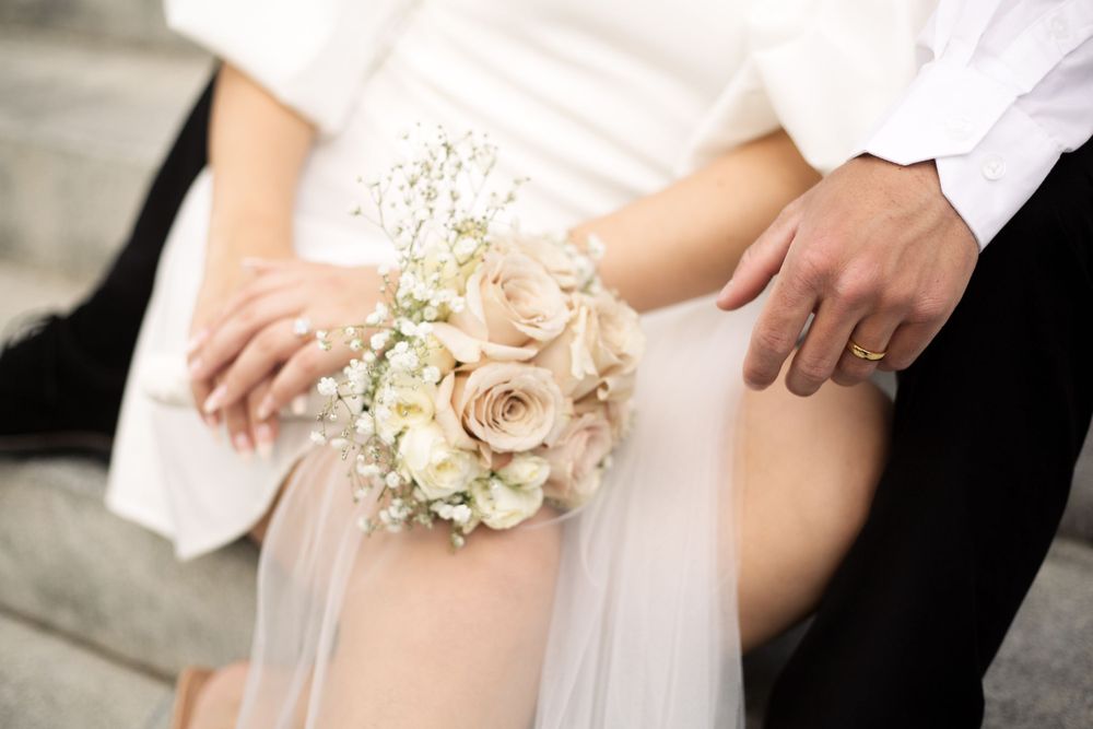 Close-up of delicate rose bouquet and wedding dress details.
