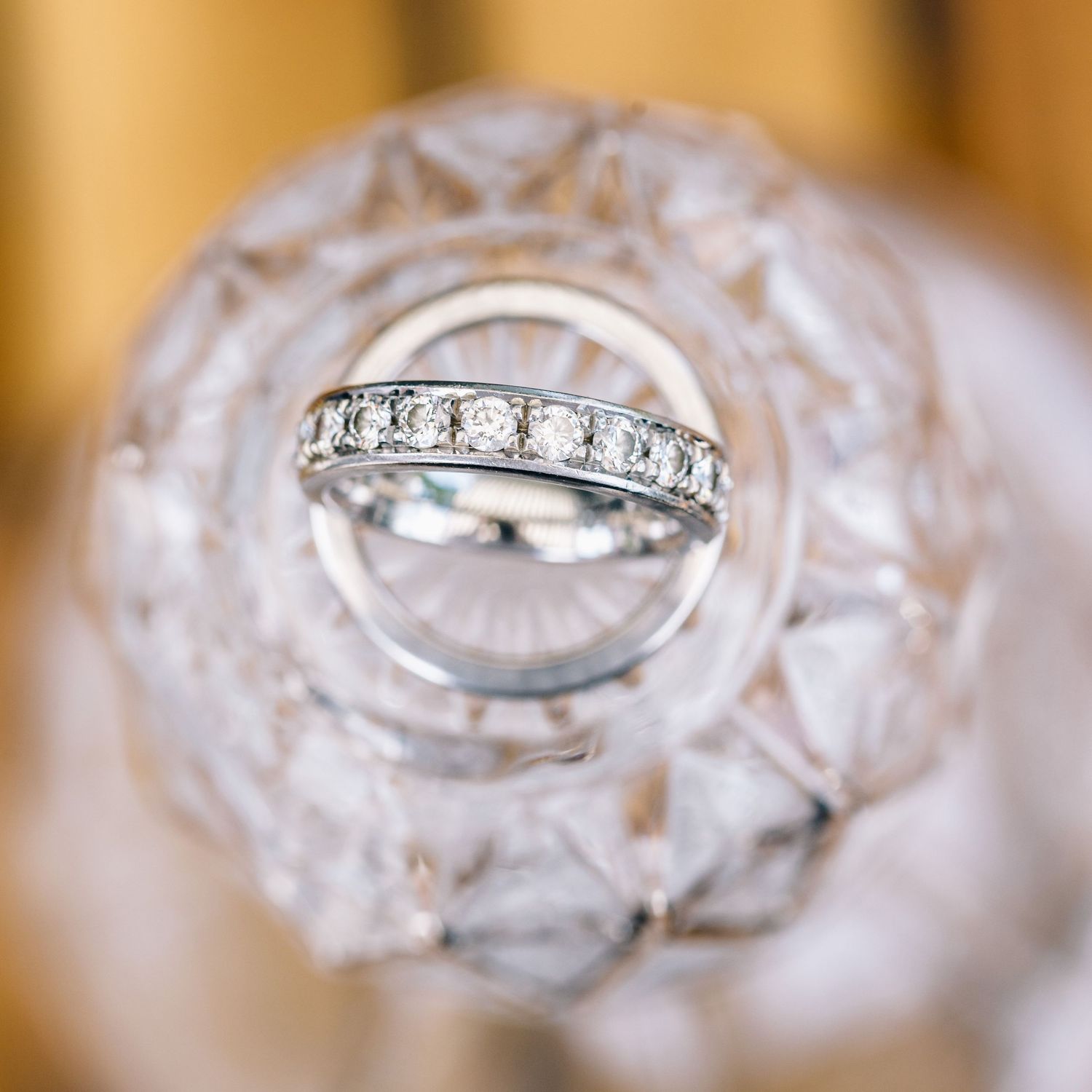 Hochzeitsfotografie - Eheringe in Nahaufnahme auf Glasflasche.