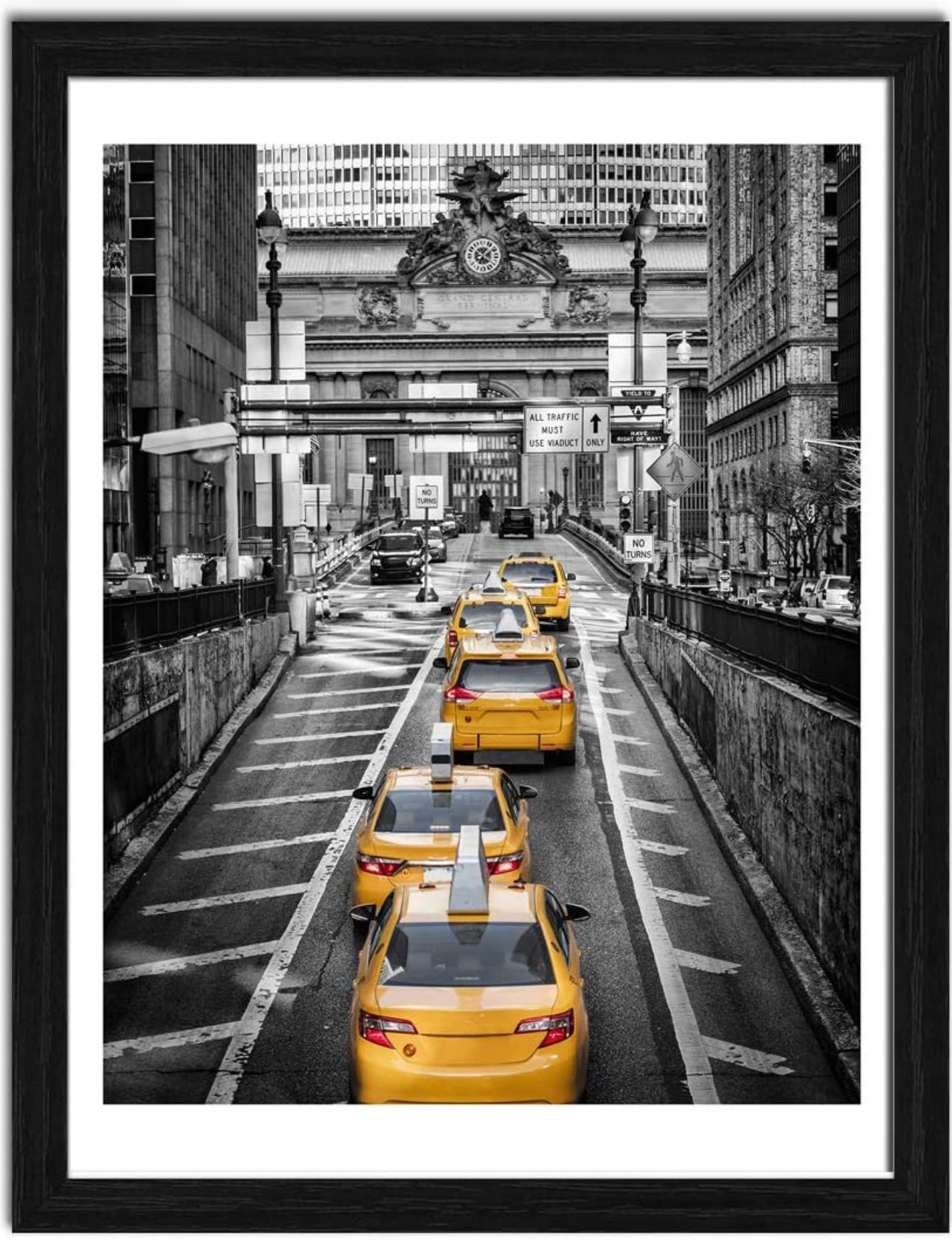 Framed black and white photo of New York City street with yellow taxis driving toward Grand Central Terminal.