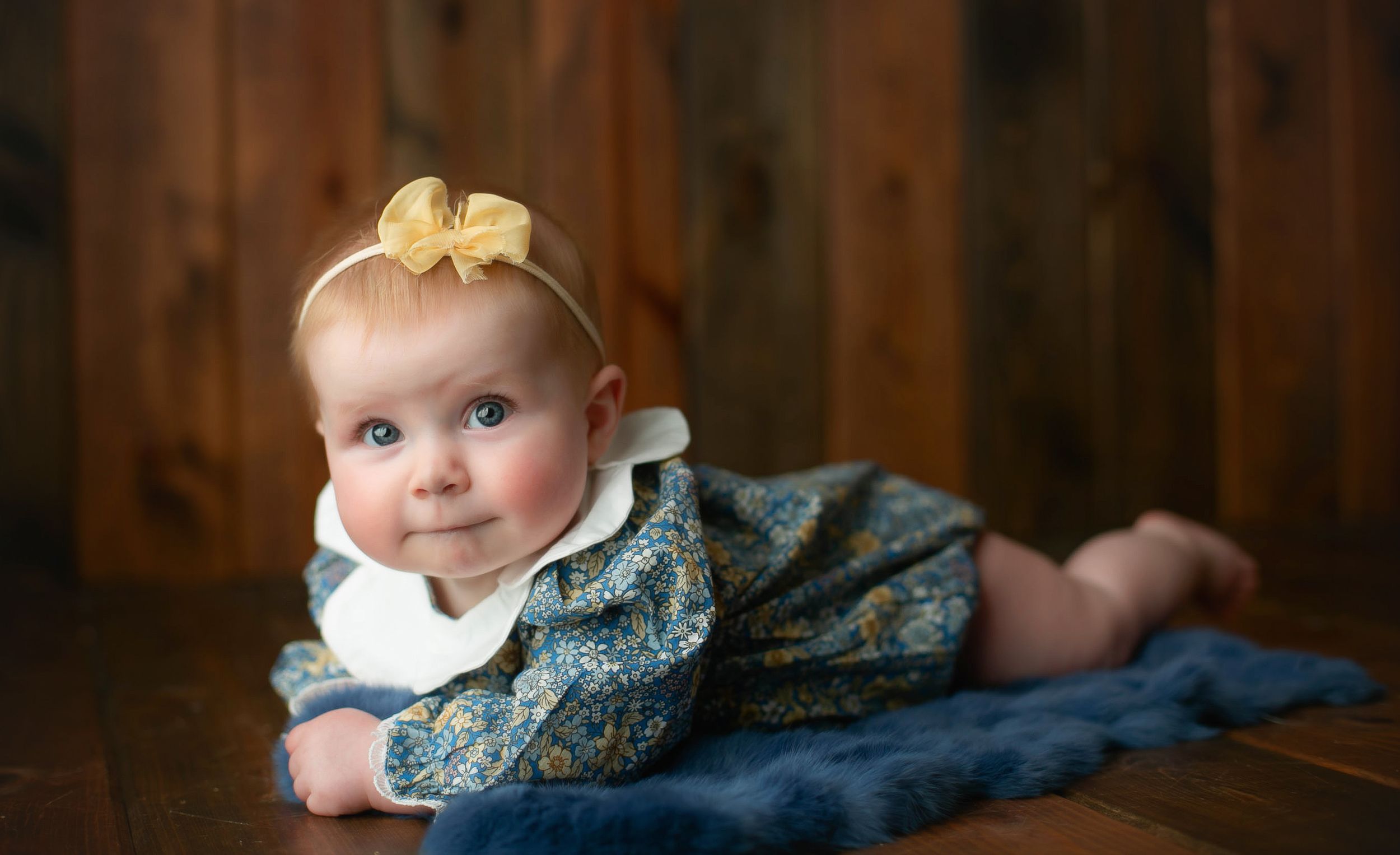 A little 6-month-old girl on her belly smiling. Greenville, SC newborn photographer, Easley, SC Newborn photographer