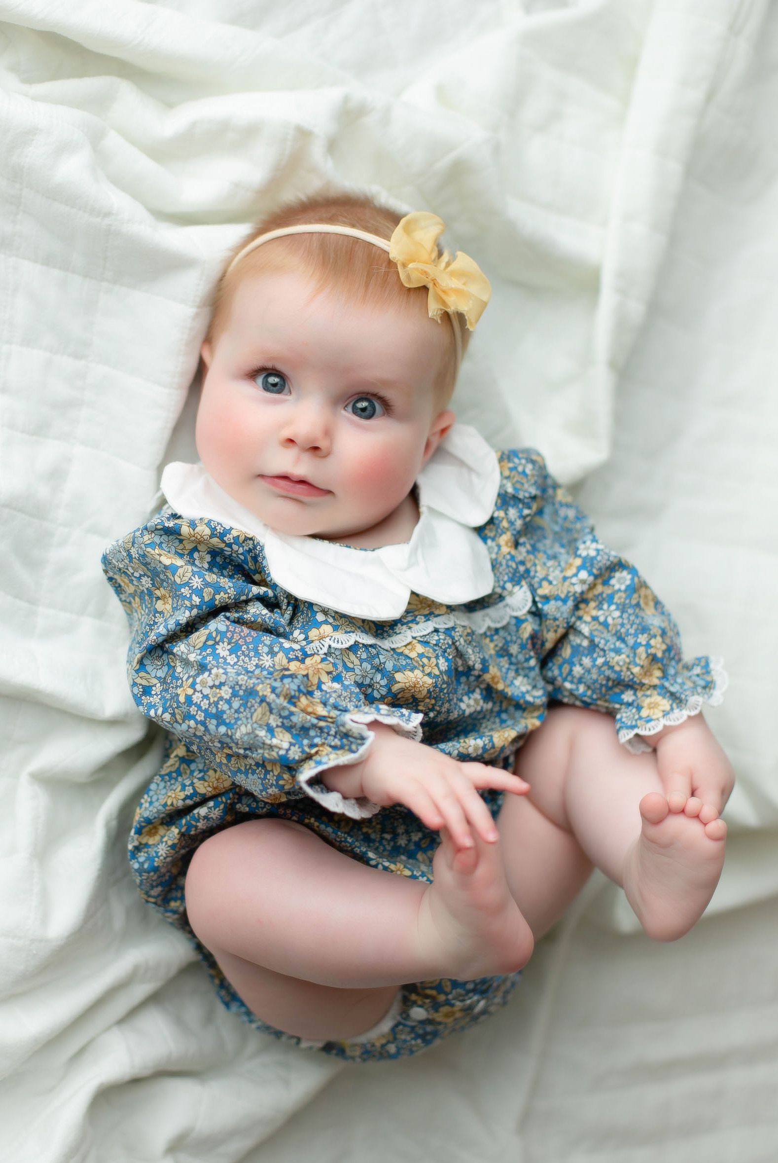 A 6 month olf lying on her back holding her feet. Greenville, SC newborn photographer, Easley, SC Newborn photographer