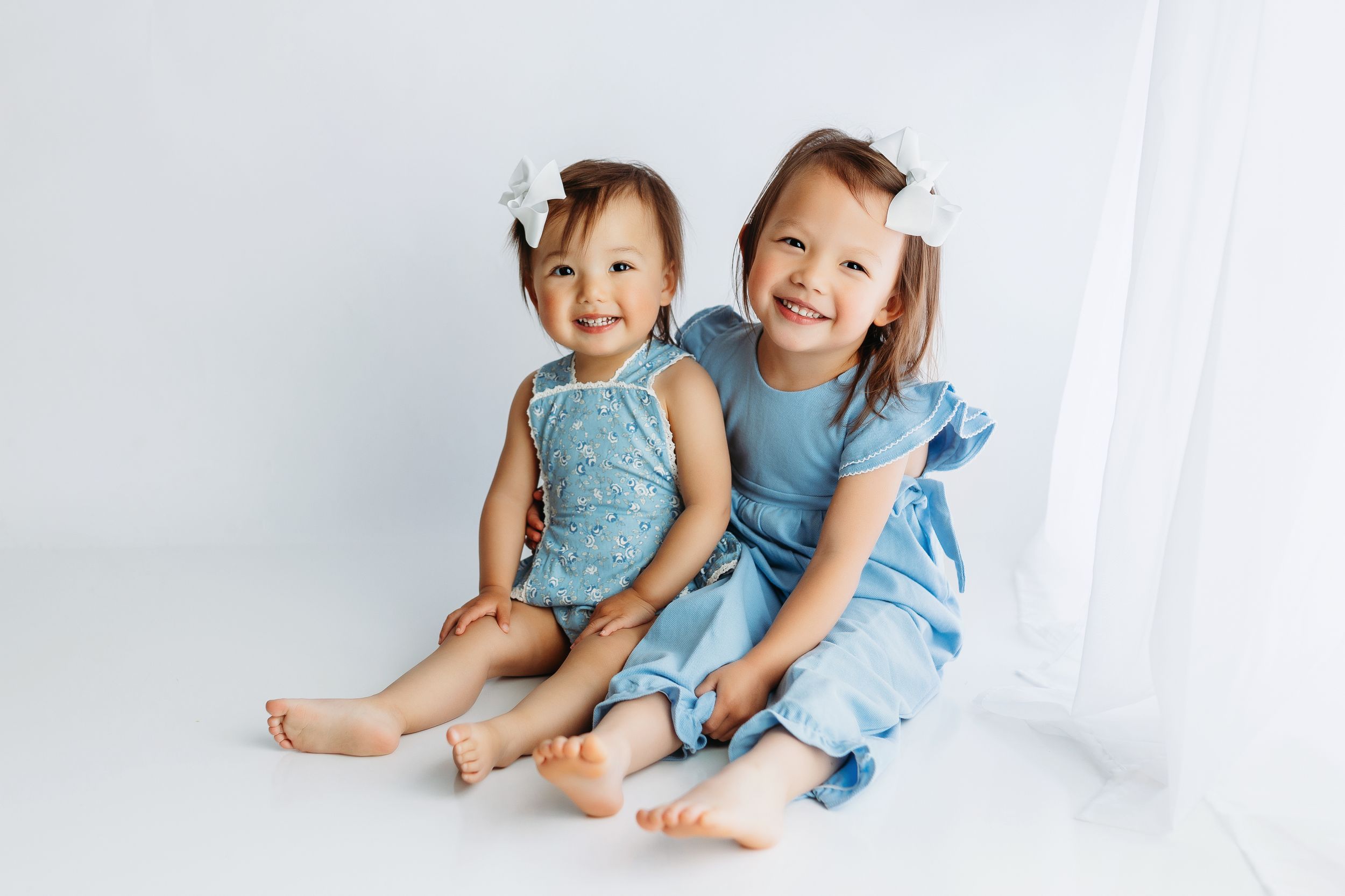 Milestone session with two sisters holding each other. Greenville, SC newborn photographer, Easley, SC Newborn photographer