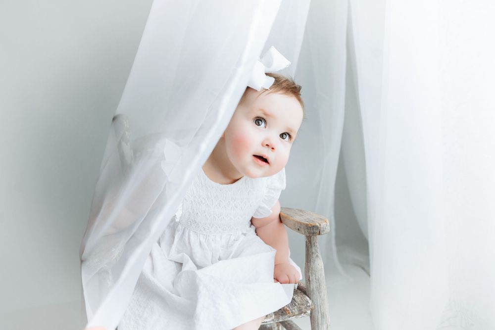A milestone session with little baby playing peek-a-boo.