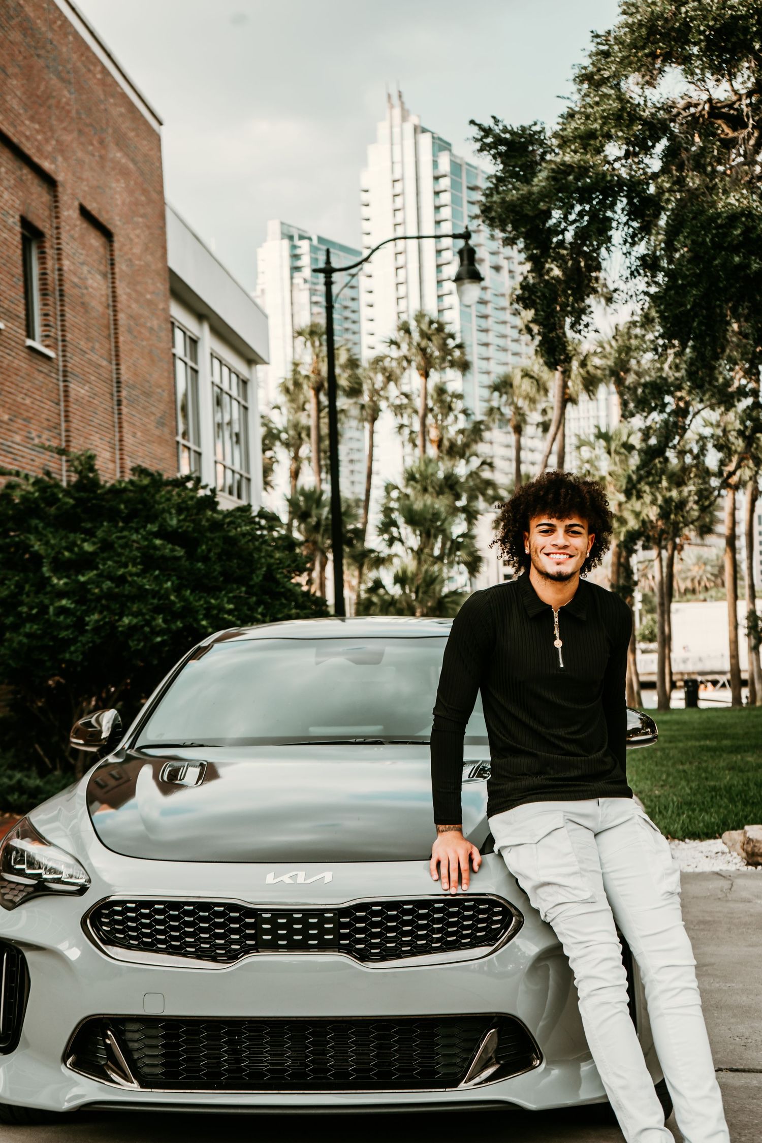 Outdoor Senior Portrait Session at University of Tampa in Tampa, FL; Senior pictures, teen leaned against hood of car