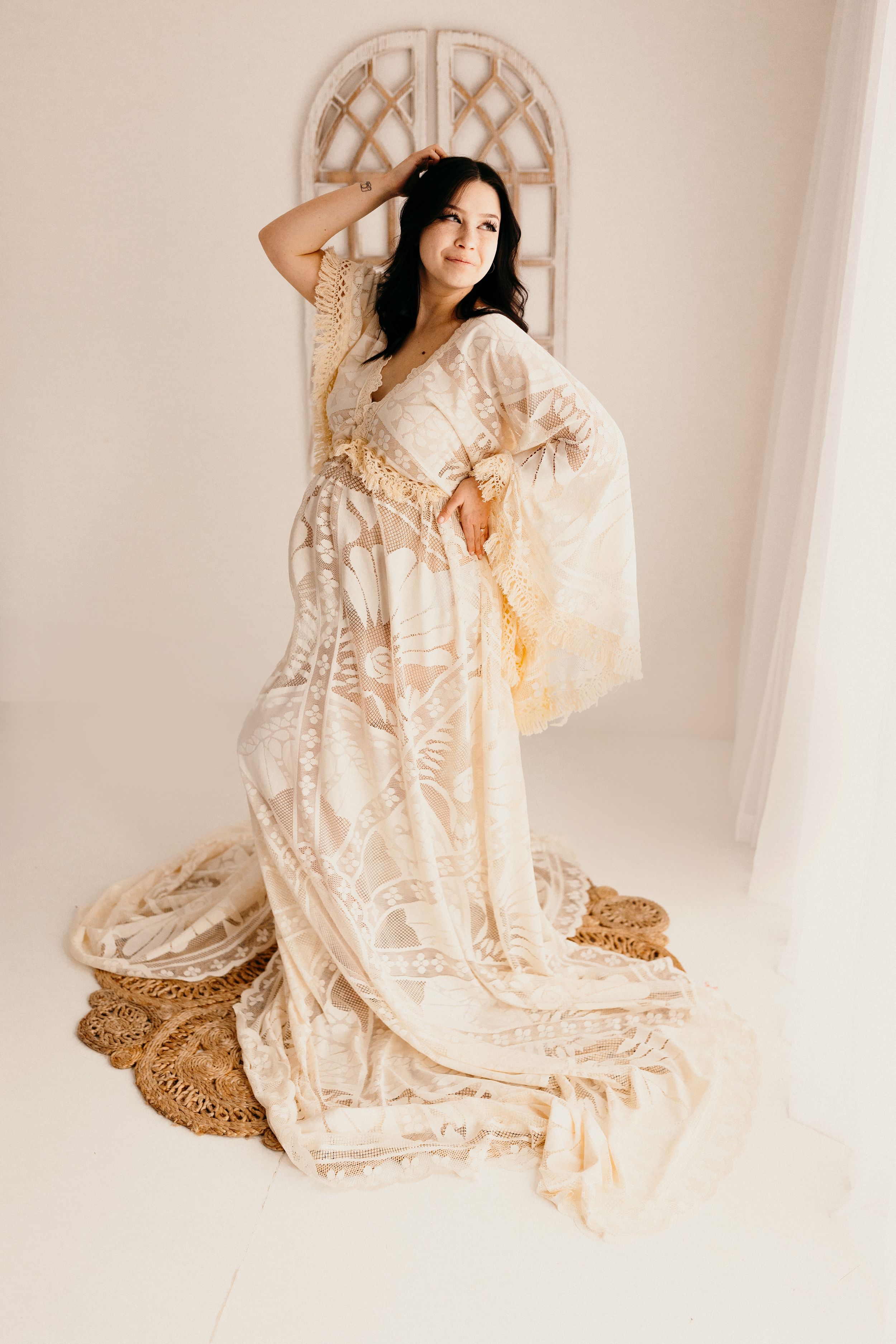 A model in a flowing cream lace dress poses gracefully against a white backdrop in a series of ethereal studio portraits.