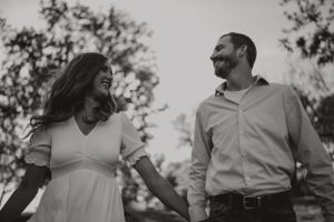 A joyful couple shares a candid moment together during an outdoor photoshoot.