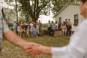 Wedding ceremony guests seated outdoors watching celebration unfold.