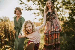 A joyful family moment captured in golden sunlight as they play together outdoors.