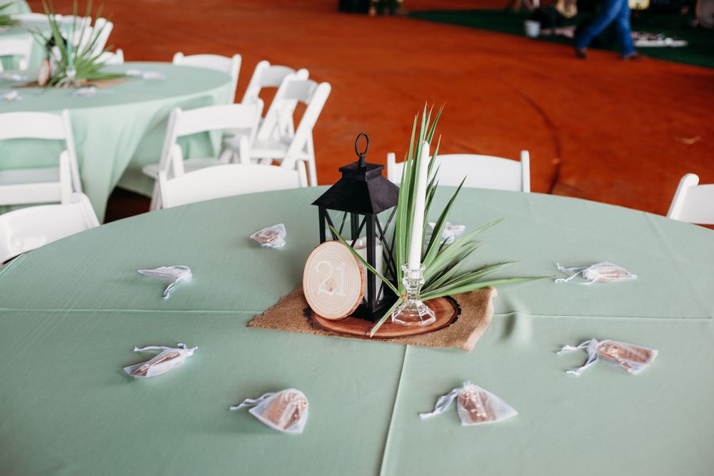 Elegant mint green tablescape with white chairs and rustic centerpiece details.