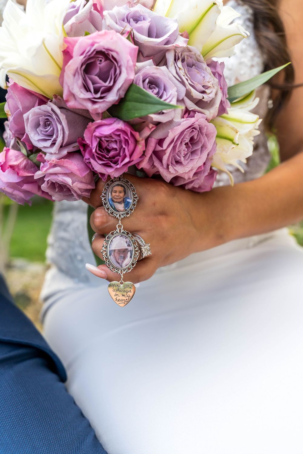 A bridal bouquet of lavender and pink roses with decorative charms attached.