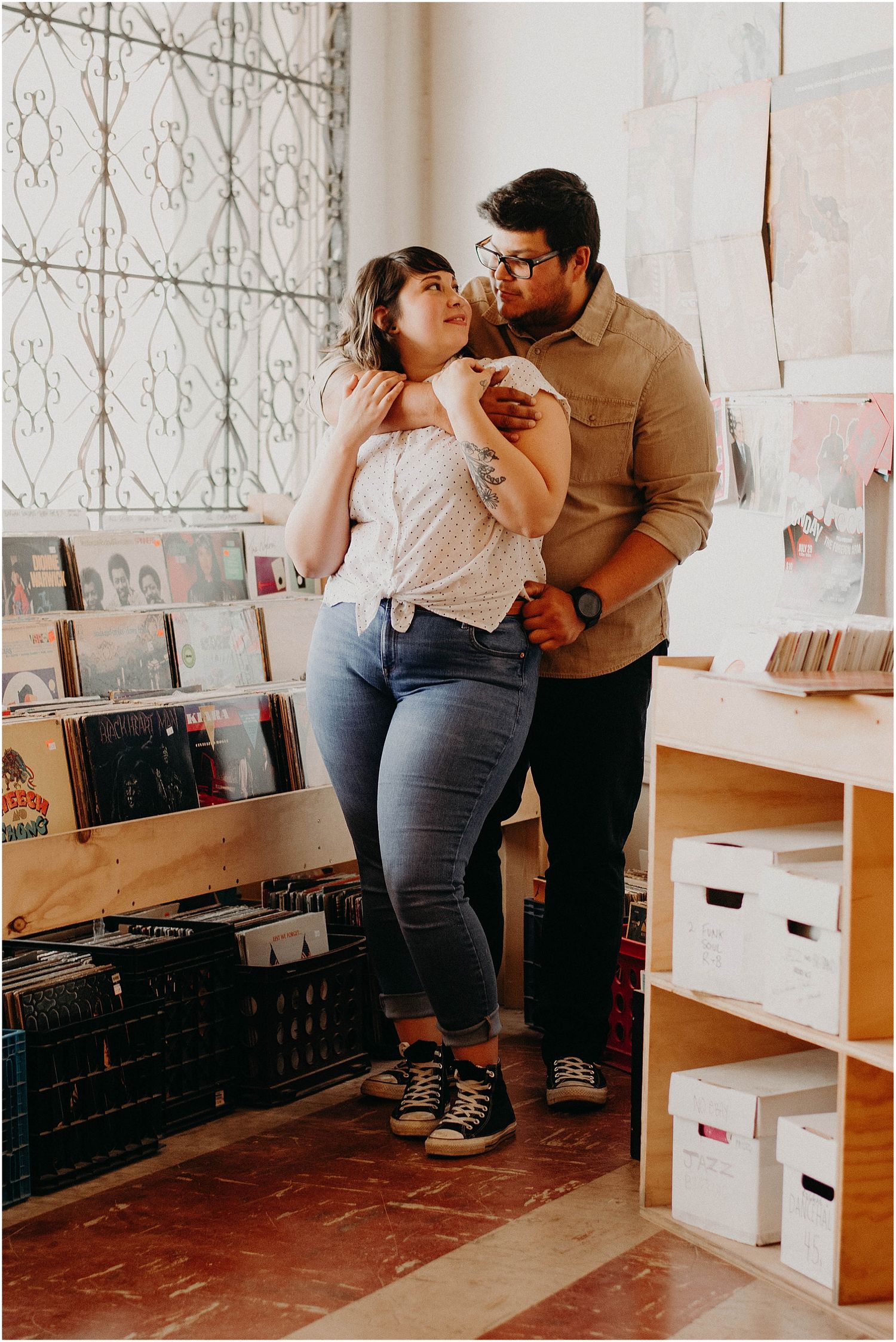 A couple shares an intimate moment while shopping for vinyl records together.